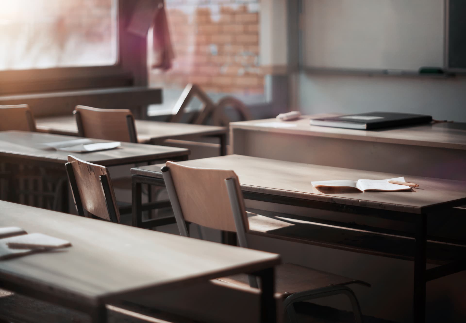 Leeres Klassenzimmer mit Reihen leerer Stühle im warmen Licht